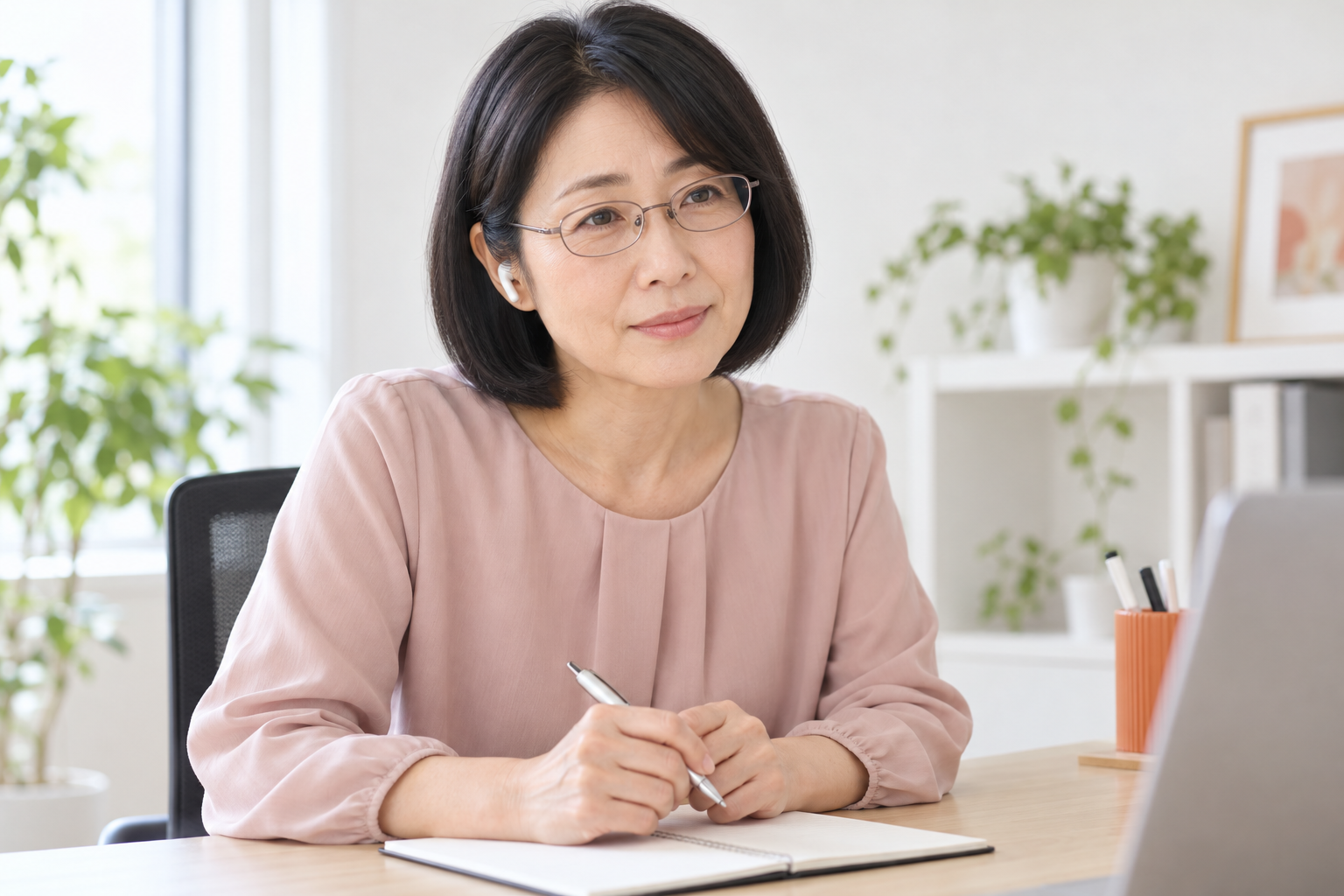 イヤホンでオンライン相談の相手の話を聴く女性講師のイメージ